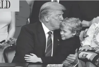  ?? EVAN VUCCI / THE ASSOCIATED PRESS ?? President Donald Trump kisses Jordan McLinn, a Duchenne Muscular Dystrophy patient, after signing the “Right to Try” act in the South Court Auditorium on the White House campus in Washington on Wednesday.