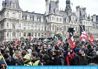  ?? —AFP ?? PARIS: Protesters demonstrat­e as part of a nationwide multi-sector strike against French government’s pensions overhaul near the city hall in Paris on Saturday.