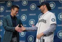  ?? (AP/Ted S. Warren) ?? Seattle Mariners President of Baseball Operations Jerry Dipoto (left) and his new pitcher Robbie Ray shake hands during a news conference in Seattle on Dec. 1. The Mariners introduced the AL Cy Young Award winner just a day before the MLB came to a screeching halt.