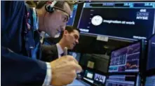  ?? RICHARD DREW — THE ASSOCIATED PRESS ?? Trader Gregory Rowe, left, and specialist John McNierney work at the post that handles General Electric on the floor of the New York Stock Exchange, Tuesday. Stocks are opening lower on Wall Street as technology companies, banks and retailers sink.