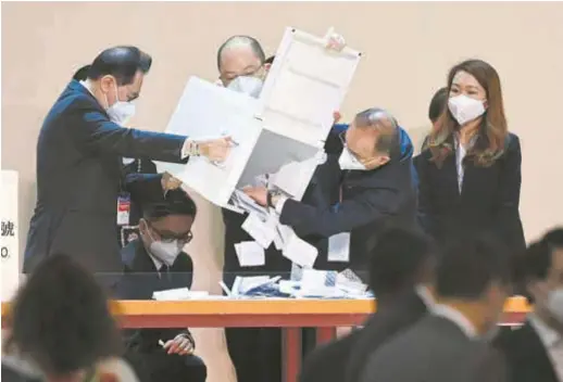  ?? . — AFP ?? A ballot box is tipped out to start the vote counting during the selection process of Hong Kong’s next chief executive yesterday. John Lee was elected as the sixth-term chief executive designate