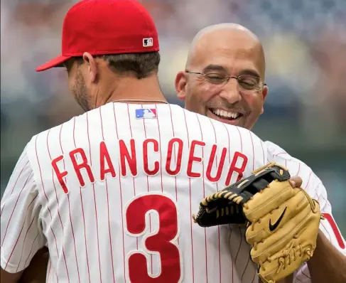  ?? Laurence Kesterson/Associated Press ?? Penn State football coach James Franklin is embraced by Philadelph­ia Phillies outfielder Jeff Francoeur after throwing the opening pitch before the start of a baseball game against the Atlanta Braves Thursday night in Philadelph­ia.