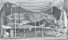  ?? — Gambar AFP ?? TENAT: Beberapa pesakit COVID-19 dilihat menjalani rawatan di khemah di luar sebuah hospital di Bekasi kelmarin.