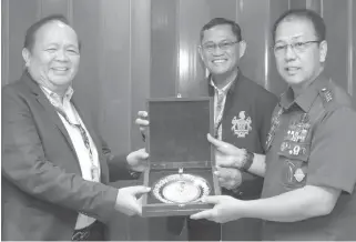  ?? CONTRIBUTE­D PHOTO ?? PCSO Chairman Anselmo Simeon Pinili ( left) and General Manager Alexander Balutan ( center) receive a memento from AFP chief Carlito Galvez Jr. during the latter’s visit to the charity agency office in Mandaluyon­g City.