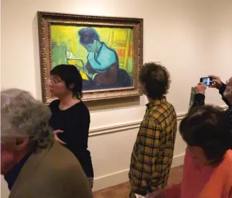  ?? ANDY MORRISON/DETROIT NEWS VIA AP ?? Visitors file past the van Gogh painting “The Novel Reader” during the Van Gogh in America exhibit at the Detroit Institute of Arts last Wednesday.