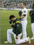  ?? ERIC RISBERG — ASSOCIATED PRESS ?? Oakland’s Bruce Maxwell, left, kneels in front of teammate Mark Canha, right, during the national Anthem Saturday in Oakland.