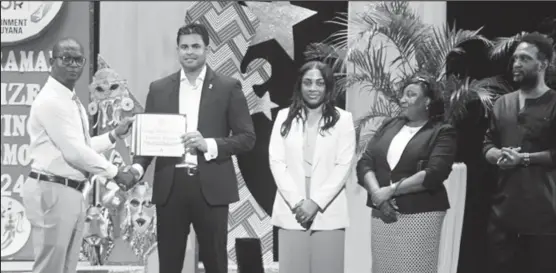  ?? ?? Minister of Culture, Youth and Sport, Charles Ramson Jr (second from left) and members from the ministry presenting a grant certificat­e to one of the new recipients. (DPI photo)