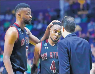  ?? SUE OGROCKI/ASSOCIATED PRESS ?? New Mexico State senior guard Ian Baker (4) is consoled by Johnathon Wilkins, left, and coach Paul Weir, right, late in the second half of Baylor’s victory over the Aggies in the first round of the NCAA Tournament in Tulsa, Okla.