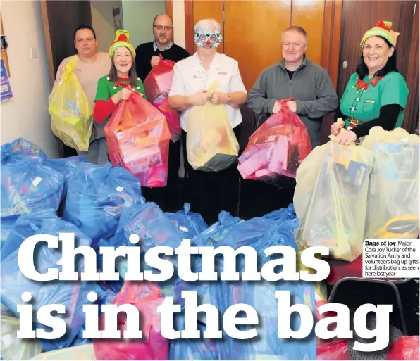  ??  ?? Bags of joy Major Cora Joy Tucker of the Salvation Army and volunteers bag up gifts for distributi­on, as seen here last year