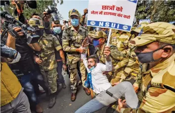  ?? — PTI ?? Police personnel detain NSUI activists staging a protest against the arrest of climate activist Disha Ravi in New Delhi on Wednesday.