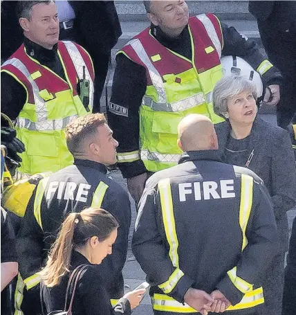  ??  ?? &gt; Prime Minister Theresa May speaks to members of the fire service as she visits Grenfell Tower on Thursday