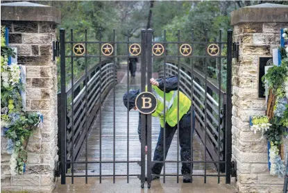  ?? Mark Mulligan / Staff photograph­er ?? A member of the grounds crew at the George Bush Presidenti­al Library in College Station closes the gate to the gravesite on Friday, the day after Bush was buried on the library’s grounds. The gravesite is expected to be opened to the public on Saturday.