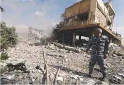  ?? REUTERSPIX ?? A Syrian firefighte­r stands outside the destroyed Scientific Research Centre in Damascus on Saturday.