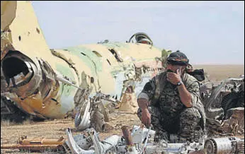  ?? REUTERS ?? A Syrian Democratic Forces fighter rests near destroyed airplane parts inside Tabqa military airport after taking control of it from Islamic State fighters, west of Raqqa city, Syria.