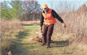  ??  ?? Jim Linstroth of Raymond drags a white-tailed deer killed during a hunt in northern Racine County on opening weekend of the 2020 Wisconsin nine-day gun deer hunting season.