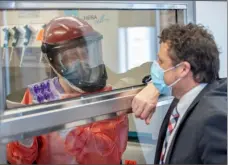  ?? Pitt Health/UPMC ?? Virologist Paul Duprex, right, talks to laboratory research technician Theron Gilliland Jr. through a glass window at the biocontain­ment laboratory at the University of Pittsburgh Center for Vaccine Research.