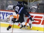  ?? THE ASSOCIATED PRESS FILE ?? The Flyers’ Jordan Weal gets crushed along the boards by Winnipeg’s Toby Enstrom in a recent game. Weal has found the going tough in a variety of ways in this, his first full NHL season.