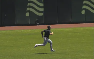  ?? Stephen Lam / Special to The Chronicle ?? Buster Posey runs in the outfield at Oracle Park last week, when he was still undecided about playing.