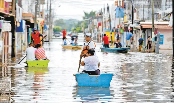  ??  ?? Los habitantes de Minatitlán utilizaron lanchas para alejarse de las zonas inundadas.