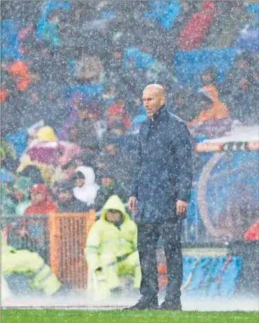  ??  ?? INTENSIDAD. Zidane, a pesar de la intensa lluvia, vio fuera de su banquillo la victoria ante el Sporting.