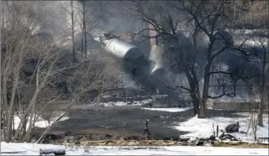  ?? CHRIS TILLEY — THE ASSOCIATED PRESS ?? A crew member walks near a train derailment outside Mount Carbon, W.Va. Tank cars carrying oil or ethanol by rail urgently need to be retrofitte­d to make them more fire-resistant, U.S. officials said Monday, after a spate of explosive accidents in...