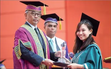  ??  ?? Tengku Abdullah hands over the award to Joanne at the convocatio­n ceremony. — Bernama photo