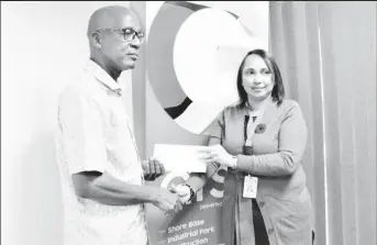  ?? ?? Minister of Labour Joseph Hamilton (left) receives a cheque from GYSBI Human Resource Manager, Lilowtie Chintamani (GYSBI photo)