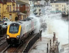  ??  ?? DRENCHED: A train copes with waves crashing at Dawlish, Devon