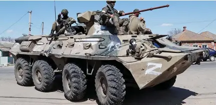  ?? ?? Threat: Pro-Russian Ukrainian troops on a Z-marked armoured personnel carrier in Bezimenne Reunion: Azovstal worker Valeria hugs her son Matvey, who was evacuated to the village earlier