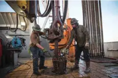  ?? — Reuters ?? Workers with Raven Drilling line up pipe while drilling for oil in the Bakken shale formation outside Watford City, North Dakota.