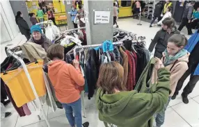  ?? CZAREK SOKOLOWSKI/AP ?? Refugees from Ukraine choose clothes at a vast accommodat­ion center set up in Warsaw, Poland, Tuesday.