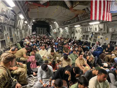  ?? ?? The 88-foot-long cargo compartmen­t of a C-17 filled with refugees sitting mostly on the floor during a flight out of Kabul, Afghanista­n. (Photo courtesy of the USAF)