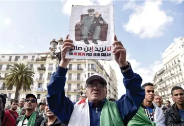  ??  ?? An Algerian protester raises a placard as he takes part in a demonstrat­ion in the capital Algiers. The placard reads in Arabic and French: “We do not want Bensalah” . — AFP photo