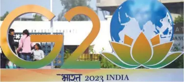  ?? Agence France-presse ?? ↑
Children stand next to the G-20 logo after its unveiling in New Delhi on Thursday.