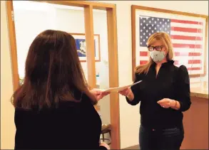  ?? Grace Duffield / Hearst Connecticu­t Media ?? Jennifer Dalipi hands the signed petition to Town Clerk Claudia Weber in New Canaan Town Hall on Tuesday. Over 102 were given to Weber, while she needed 50 at this step.