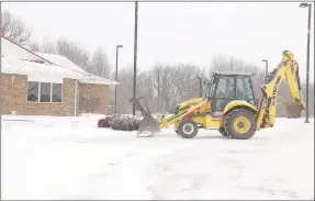  ?? LYNN KUTTER ENTERPRISE-LEADER ?? Floyd Shelley, Farmington’s public works manager, clears off the parking lot for the public library on Monday morning. Farmington received at least five inches of snow Sunday and Monday.