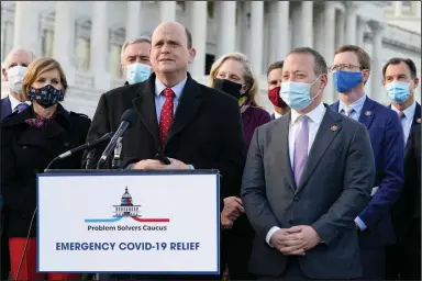  ?? (AP/Jacquelyn Martin) ?? Problem Solvers Caucus co-chairmen Rep. Tom Reed, R-N.Y. (at podium) and Rep. Josh Gottheimer, D-N.J. speak Monday to the media with members of their caucus about the expected passage of the emergency covid-19 relief bill on Capitol Hill in Washington.