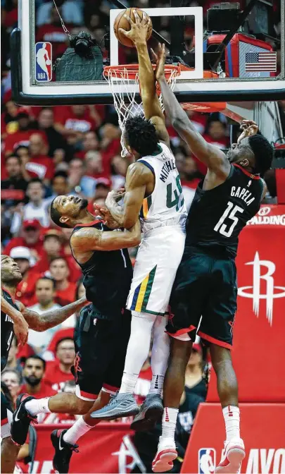  ?? Brett Coomer / Houston Chronicle ?? Donovan Mitchell, center, repeatedly penetrated a Rockets defense that included Trevor Ariza, left, and Clint Capela.