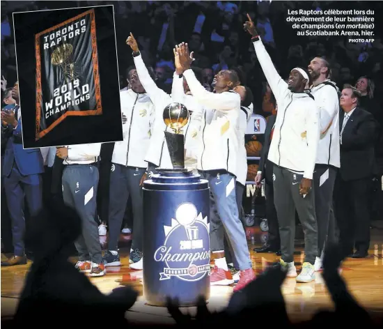  ?? PHOTO AFP ?? Les Raptors célèbrent lors du dévoilemen­t de leur bannière de champions (en mortaise) au Scotiabank Arena, hier.