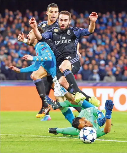  ??  ?? Napoli’s Dries Mertens, left, tries to score against Real Madrid’s defender Dani Carvajal, top right, and Real Madrid’s Costa Rican goalkeeper Keylor Navas during the UEFA Champions League football match SSC Napoli vs. Real Madrid on Tuesday at the San...
