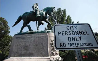 ?? AP Photo/Steve Helber ?? ■ A No Trespassin­g sign is displayed in front of a statue of Robert E. Lee on Monday in Charlottes­ville, Va., at the park that was the focus of the Unite the Right rally. Pressure to take down monuments honoring slain Confederat­e soldiers and the generals who led them didn’t start with Charlottes­ville. But the deadly violence that rocked the Virginia college town a year ago gave the issue an explosive momentum.