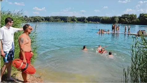  ?? Foto: Christian Mühlhause ?? Michael Dinkelmeie­r (links) und Manuel Brandt von der Wasserwach­t beobachten das Geschehen am Riedlinger Baggersee.