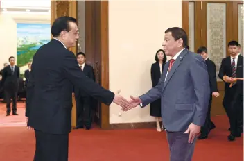  ?? POOL FOTO VIA AP ?? MEETING WITH CHINA. President Rodrigo Duterte, right, is greeted by Chinese Premier Li Keqiang prior to their meeting at the Great Hall of the People in Beijing Monday.