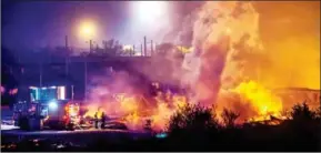  ?? PHILIPPE HUGUEN/AFP ?? Firefighte­rs work to extinguish a huge blaze at the Grande-Synthe migrant camp outside the northern French city of Dunkirk late on Monday.