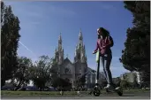  ?? JEFF CHIU — THE ASSOCIATED PRESS FILE ?? A woman rides a motorized scooter in Washington Square Park in San Francisco.