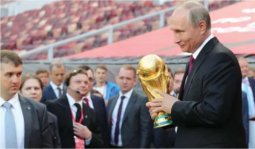  ??  ?? Russian President Vladimir Putin with the FIFA World Cup trophy