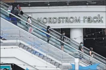  ?? Damian Dovarganes The Associated Press ?? People shop at the Nordstrom Local DTLA in downtown Los Angeles on March 15. Economists don’t foresee an imminent recession, at least not before next year.