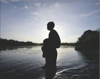  ?? AP PHOTO/FERNANDO LLANO ?? A father carries his daughter over the Rio Grande river toward Del Rio, Texas, from Ciudad Acuna, Mexico, in 2021.