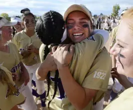  ?? Cliff Grassmick, Daily Camera ?? Ava Kuszak, right, hugs Essynce Contrerez, after Holy Family beat D’evelyn 10-4 to win the Class 4A state softball championsh­ip.