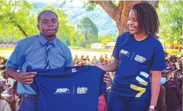  ?? NMB Bank Mutare branch manager, Mrs Sifiso ?? St Dominic’s High School learner, Joshua Magadza receives a T-shirt from Mutema